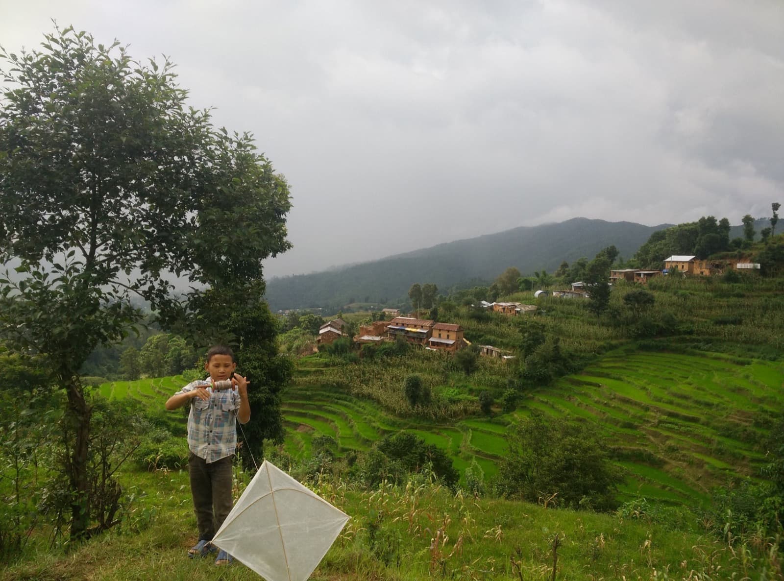 Local boy flying a kite in Nagarkot village, seen on cultural hiking trail near Kathmandu
