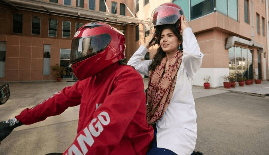 Pathao ride-sharing motorbike rider at night — red jacket with Pathao branding in city traffic