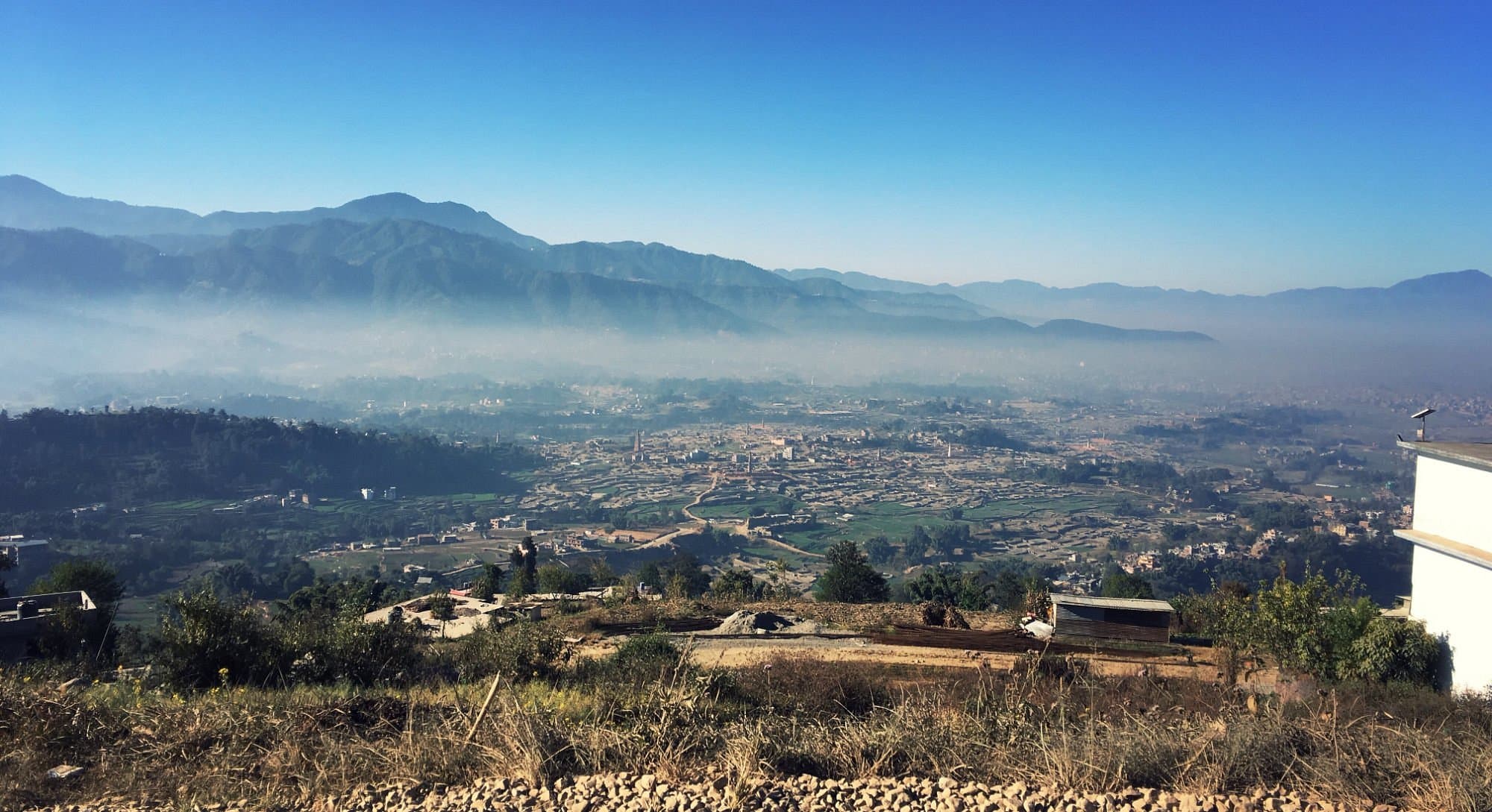 Wide view over the Kathmandu Valley from a forested western ridge